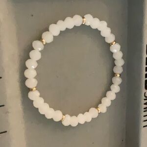 A white crystal bracelet with gold separators